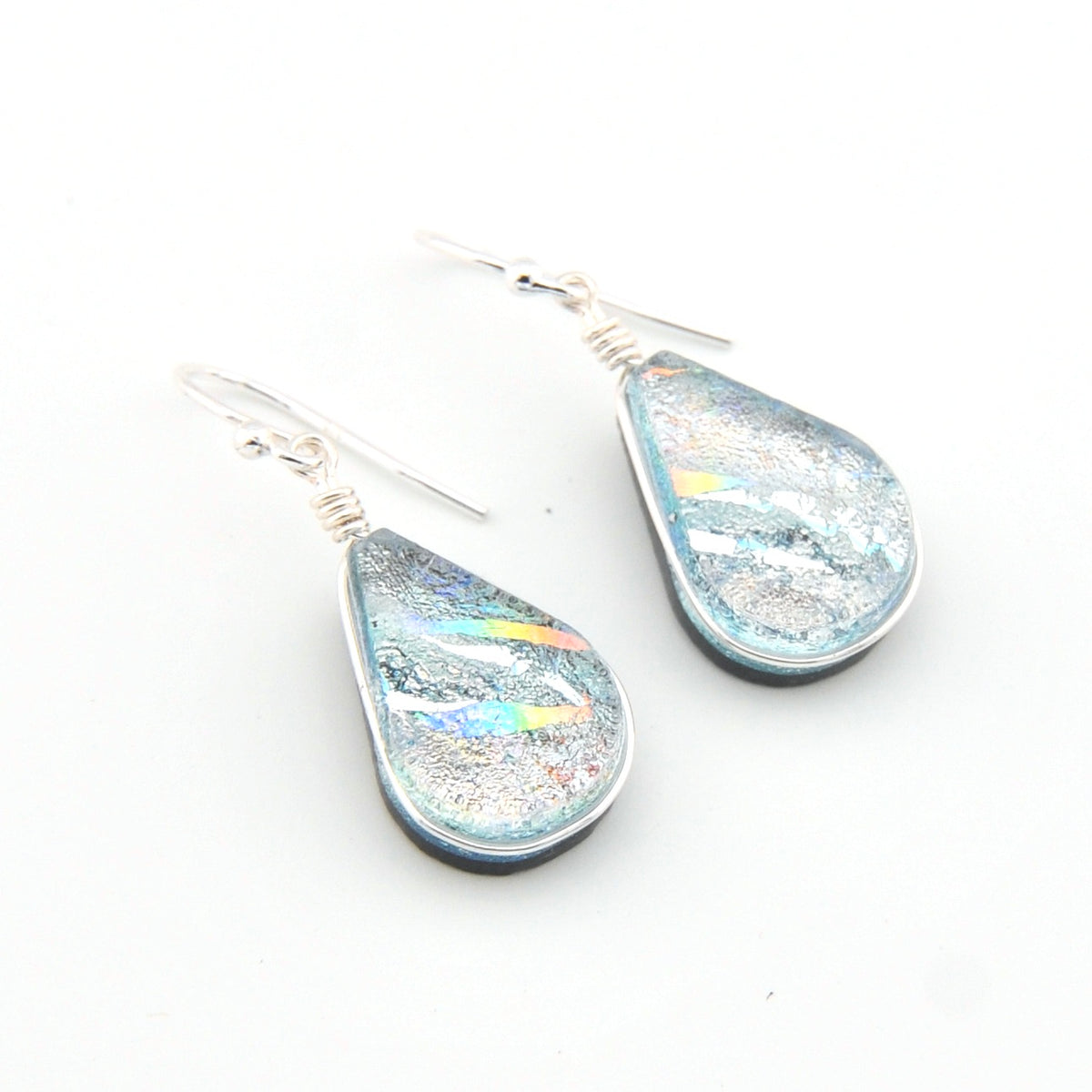 Teardrop-shaped earrings with iridescent finish on a white background