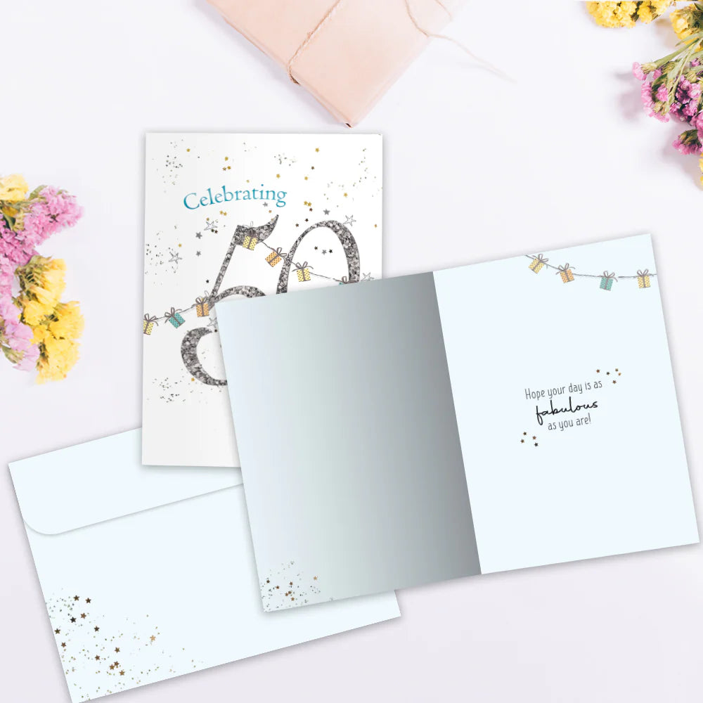 Greeting card with celebratory design on a white surface with flowers.