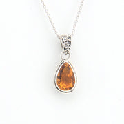 Teardrop-shaped citrine pendant on a silver chain against a white background