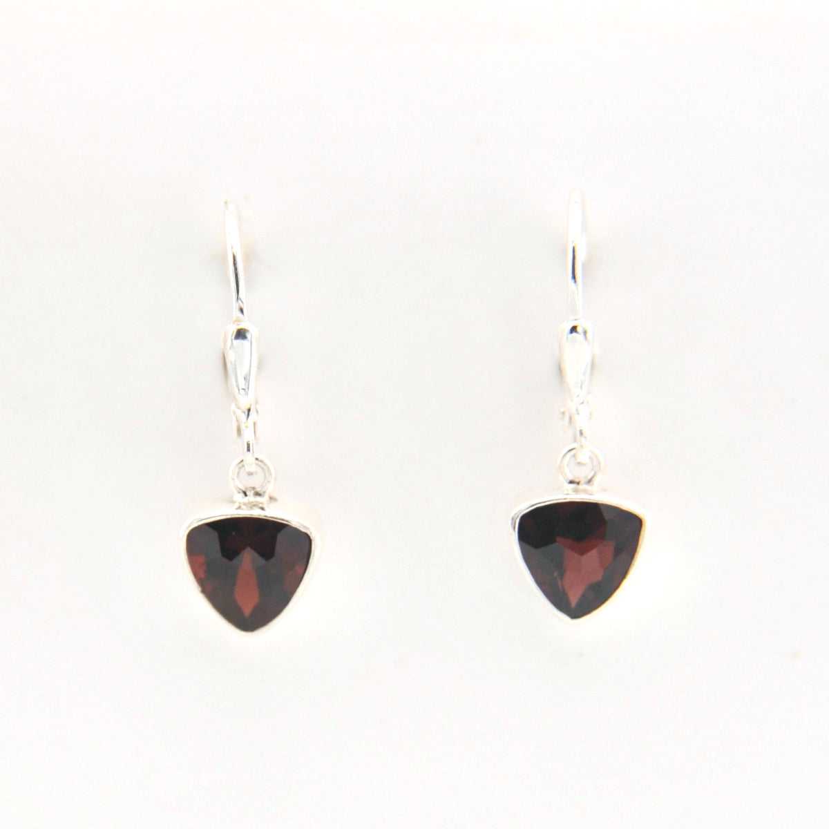 Pair of silver earrings with red gemstones on a white background