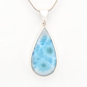 Teardrop-shaped larimar pendant on a white background
