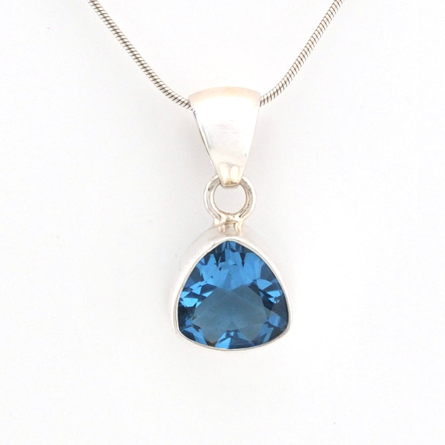 Blue trillion pendant on a silver chain against a white background
