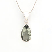 Teardrop-shaped green gemstone pendant on a silver chain against a white background