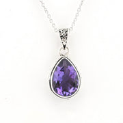 A silver teardrop pendant necklace featuring a faceted purple gemstone, suspended from a delicate silver chain against a plain white background.