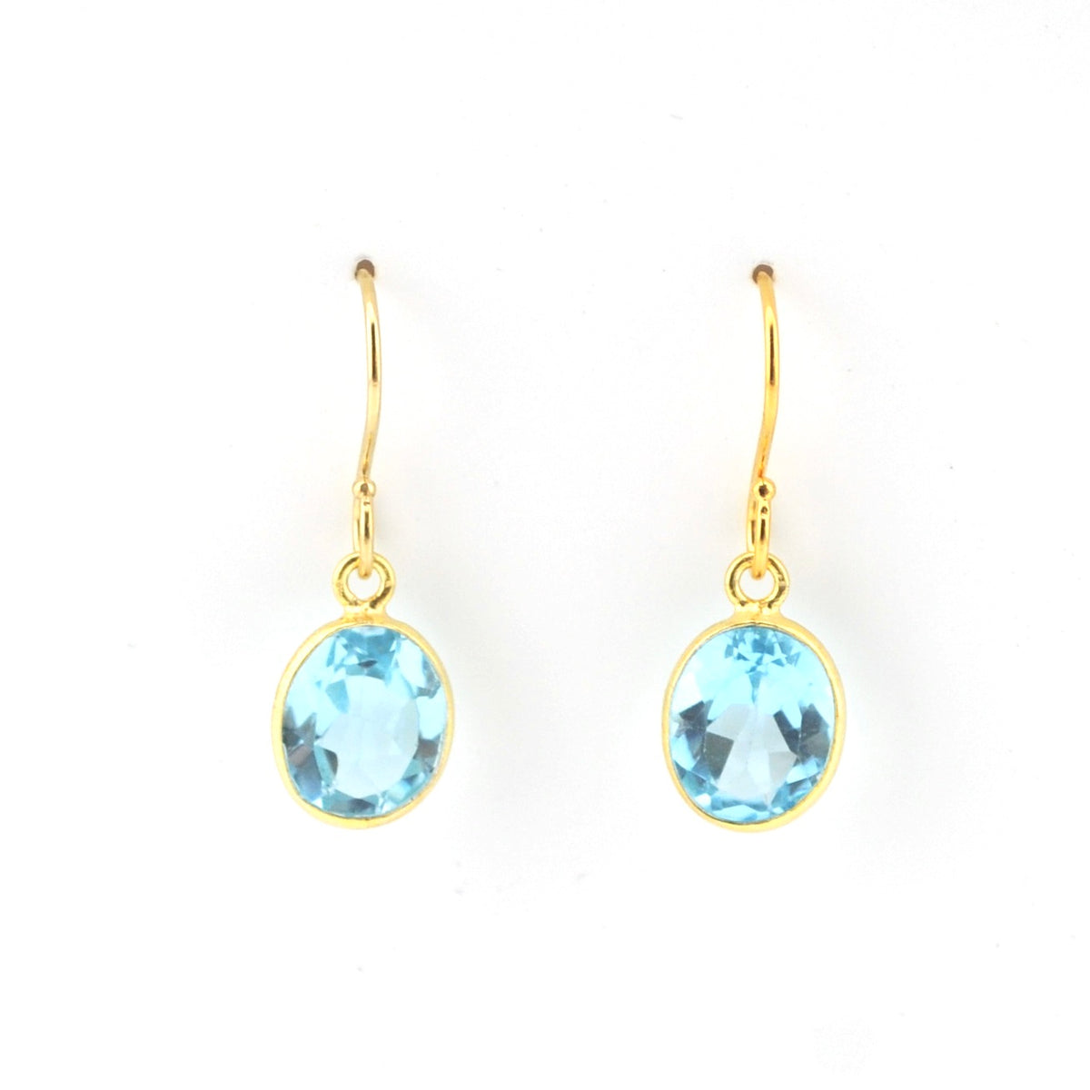 Gold earrings with blue gemstones on a white background