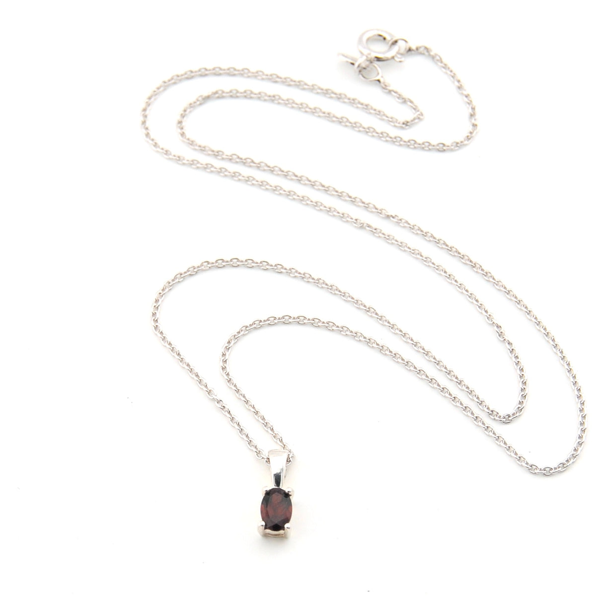 Silver necklace with a dark gemstone pendant on a white background