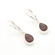 Silver earrings with teardrop-shaped gemstones on a white background