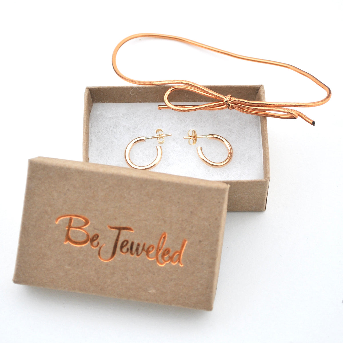 Gold hoop earrings in a 'Be Jeweled' box on a white background