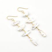 Pearl earrings with gold hooks on a white background