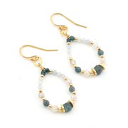 A pair of gold-tone drop earrings with beaded loops featuring dark teal, pale blue, and white beads, shown on a plain white background.