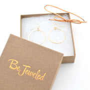 Gold hoop earrings in a 'Be Jeweled' box on a white background