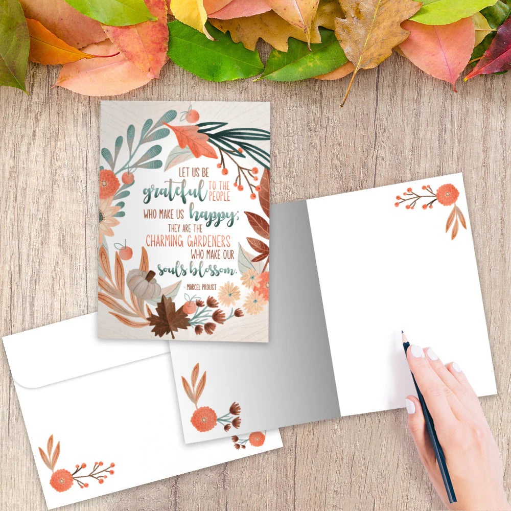 Autumn-themed card with envelope and decorative elements on a wooden surface.