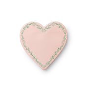 Heart-shaped pink object with green floral patterns on a white background