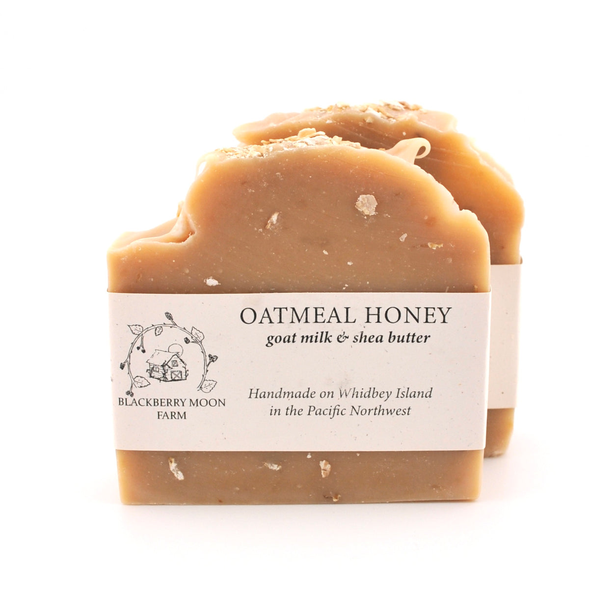 Bar of oatmeal honey soap with a label on a white background