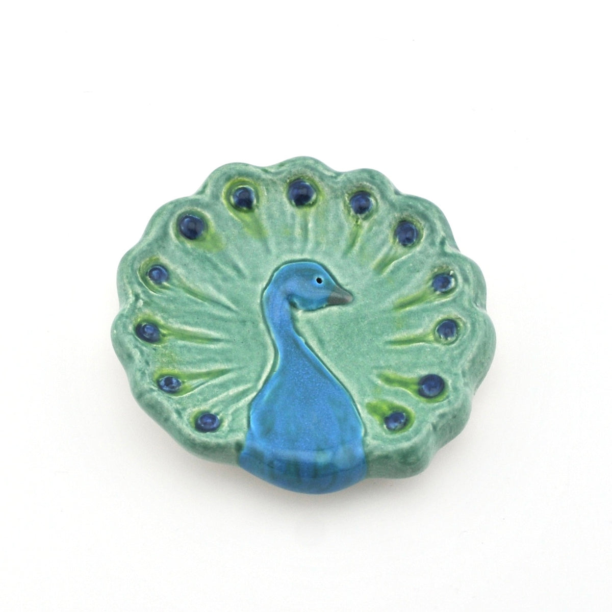 Ceramic peacock dish with blue and green colors on a white background