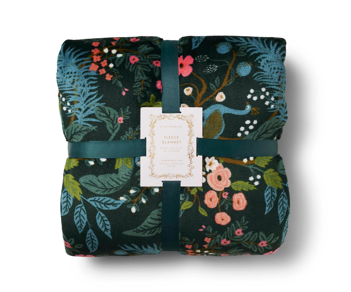 Folded floral blanket with a tag on a white background