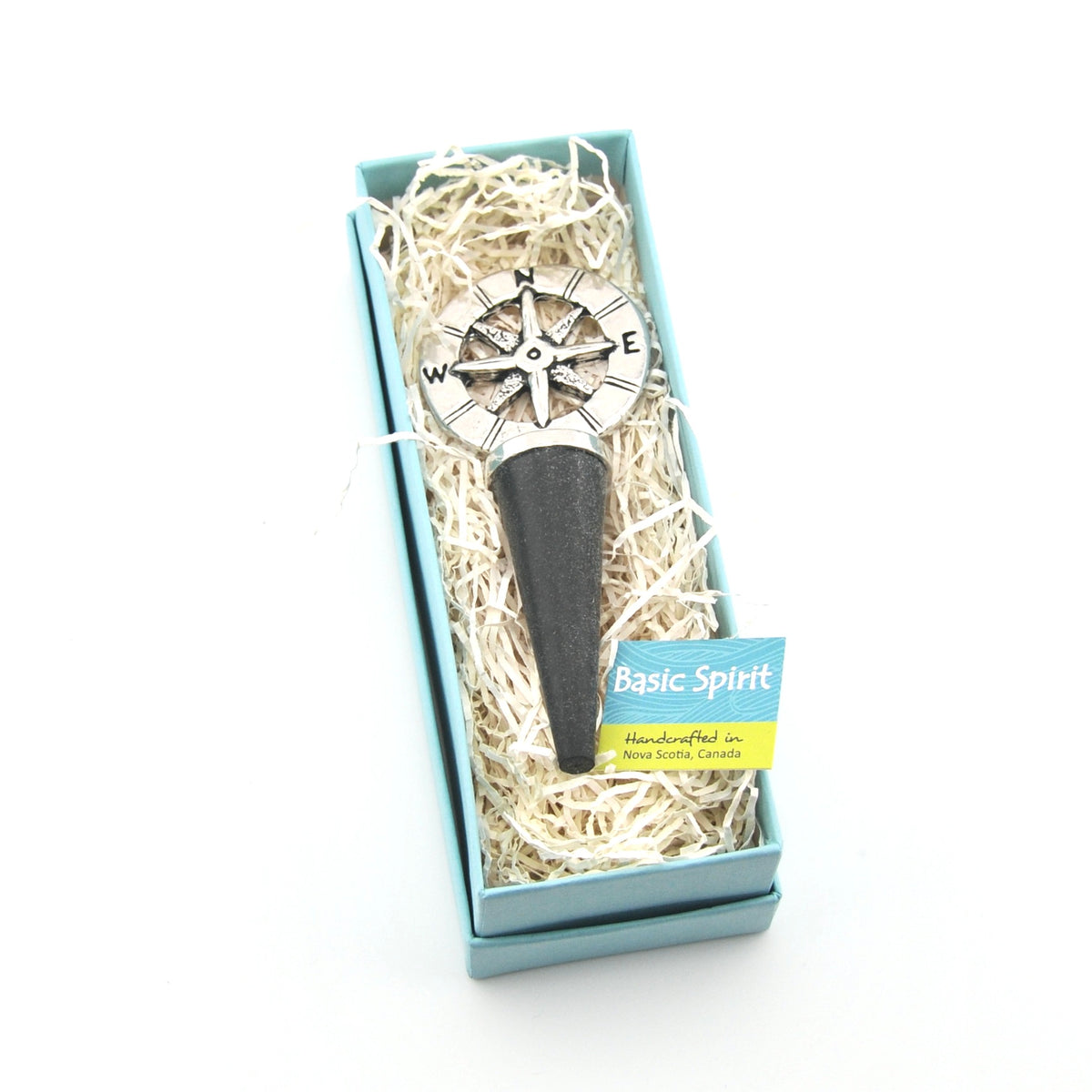 Compass bottle stopper in a decorative box with 'Basic Spirit' label on a white background