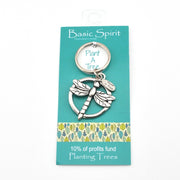 Silver dragonfly keychain on a 'Basic Spirit' branded card with teal background