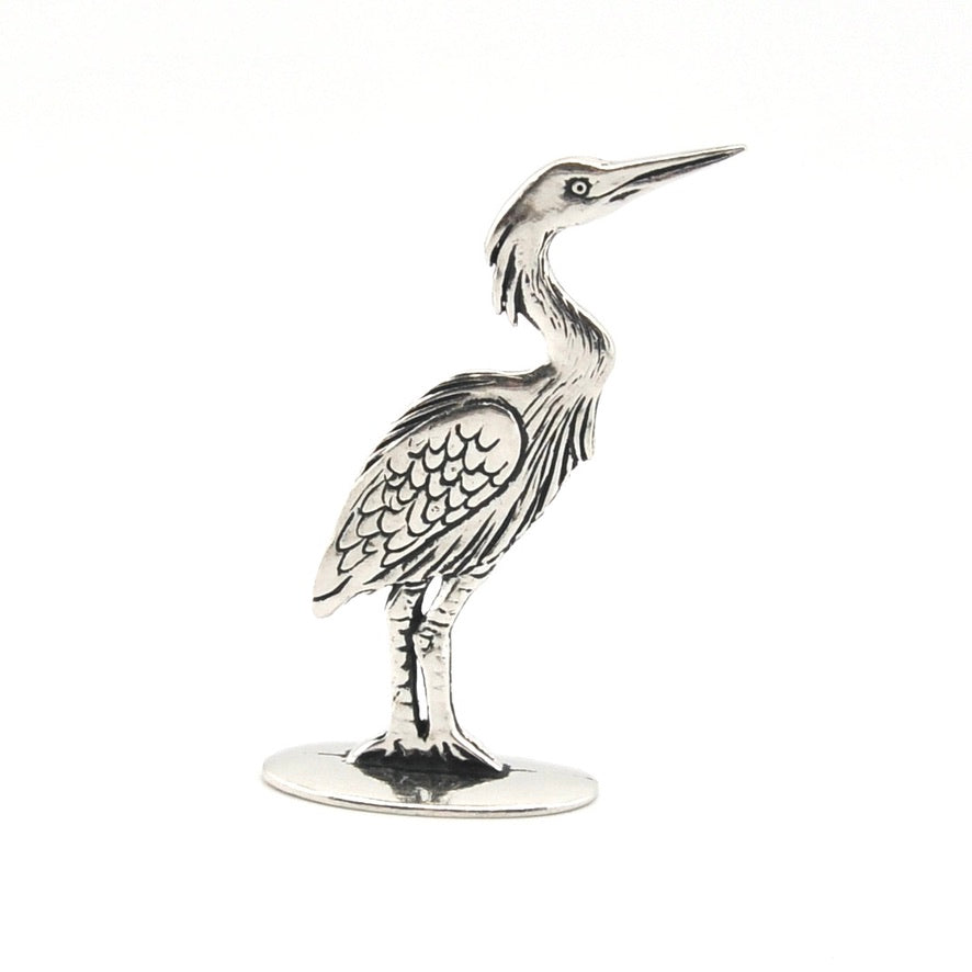 Silver heron figurine on a white background