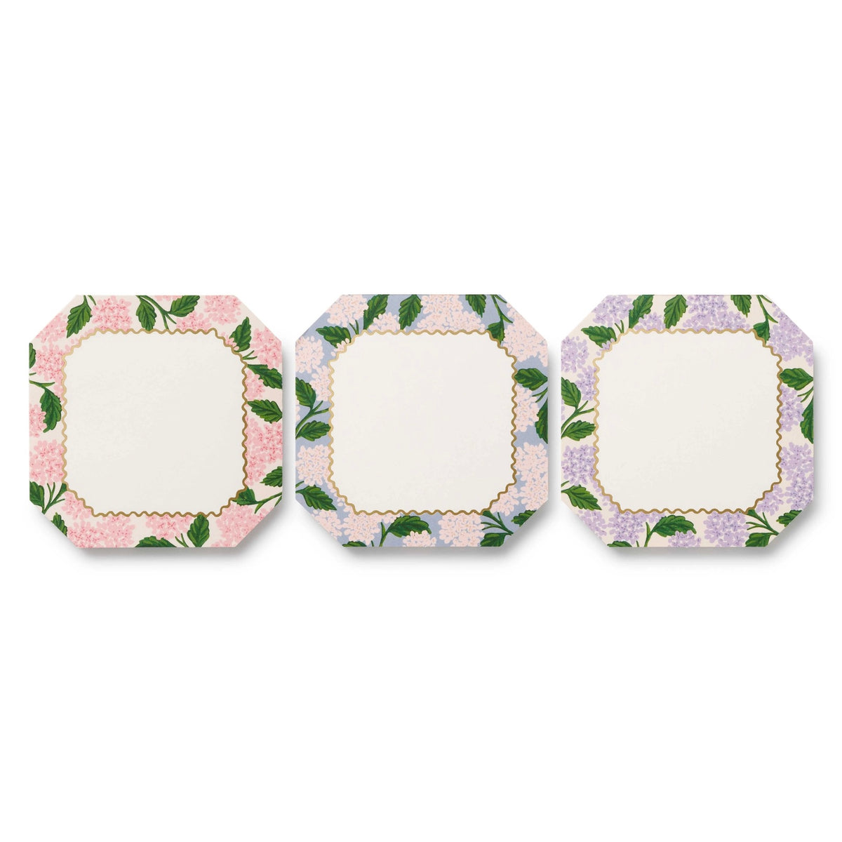 Three square plates with floral border designs on a white background