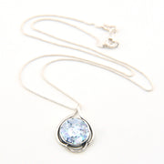 Necklace with a pendant featuring a blue gemstone on a white background