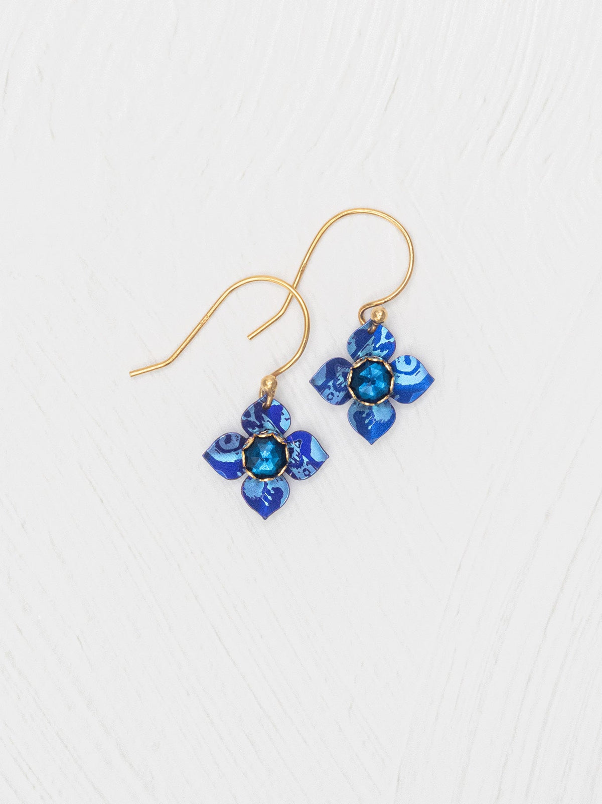 Blue flower-shaped earrings on a white background