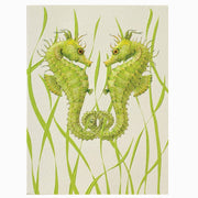Two green seahorses intertwined among grass-like plants on a beige background