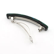 A curved hair claw clip featuring a dark green and black iridescent dichroic glass and silver-tone metal hardware, shown on a plain white background.