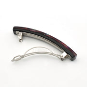 A curved hair barrette with a dark, marbled black and burgundy glass top and a silver-tone metal frame and spring, shown on a plain white background.