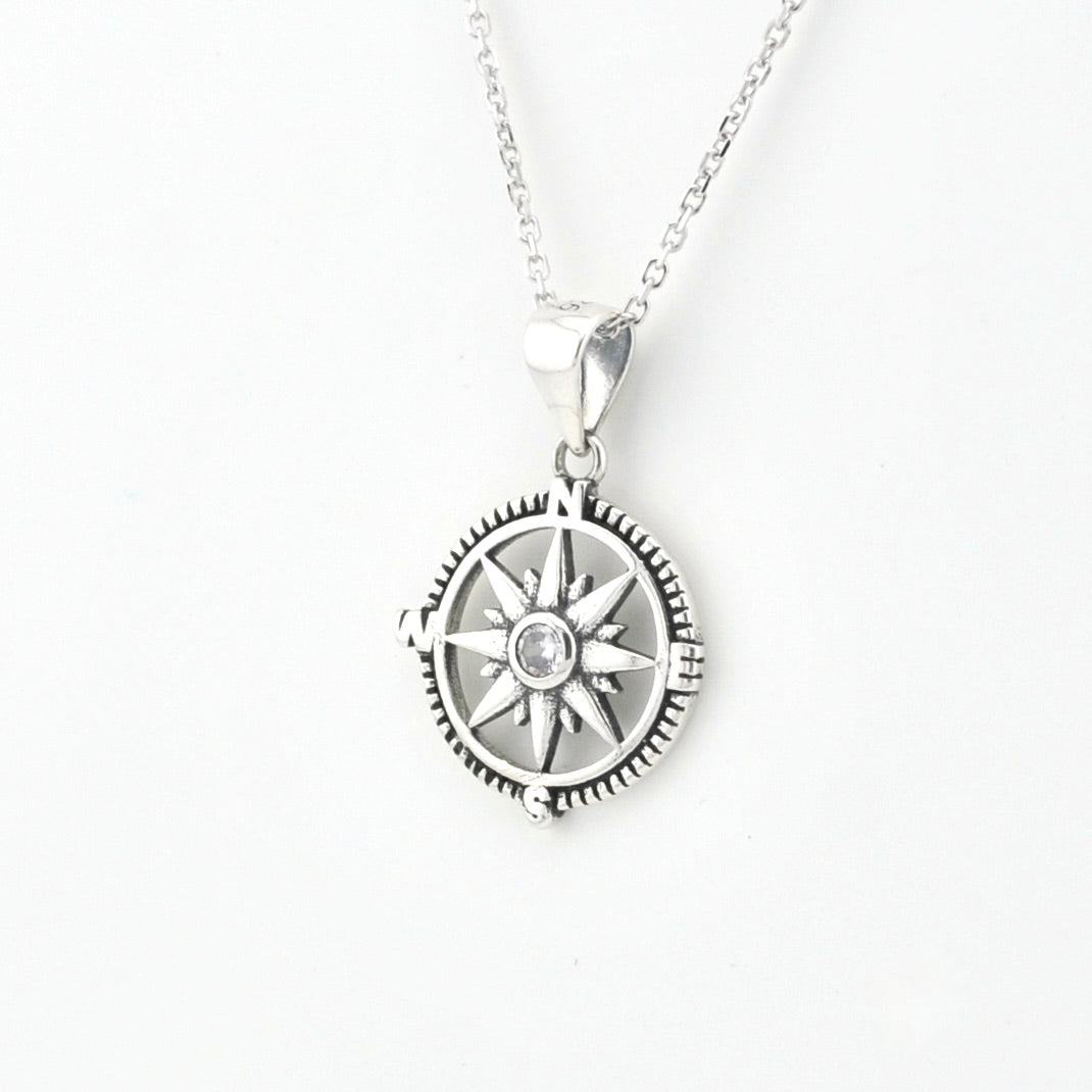 A silver compass pendant necklace on a delicate silver chain, shown against a plain white background.