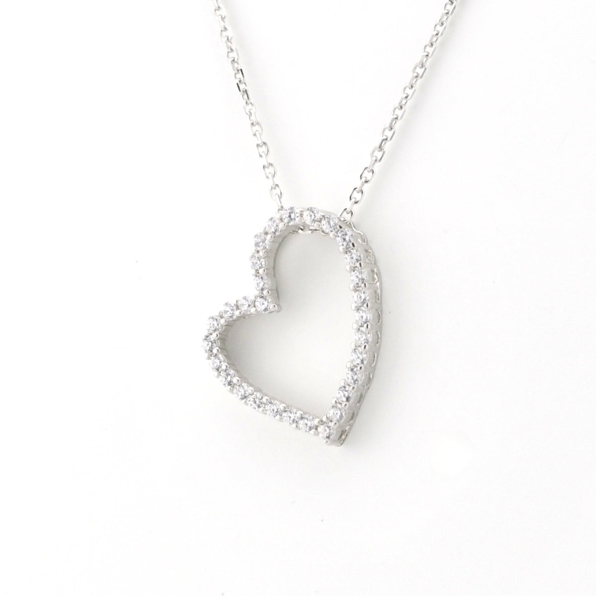 A silver heart-shaped pendant necklace with a delicate chain, featuring a border of small clear stones, shown against a plain white background.