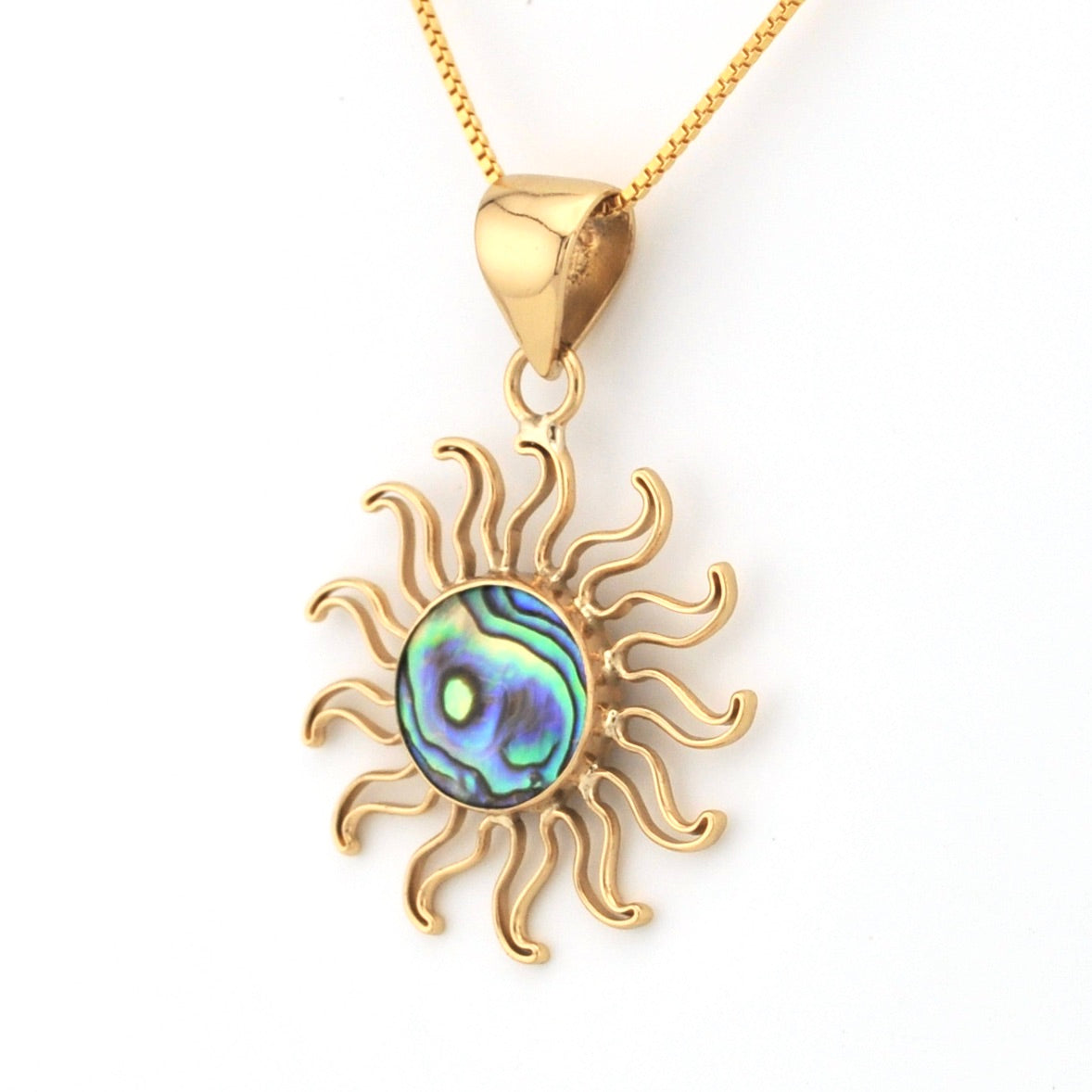 Gold sun-shaped pendant with a colorful center on a white background