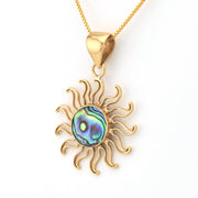 Gold sun-shaped pendant with a colorful center on a white background