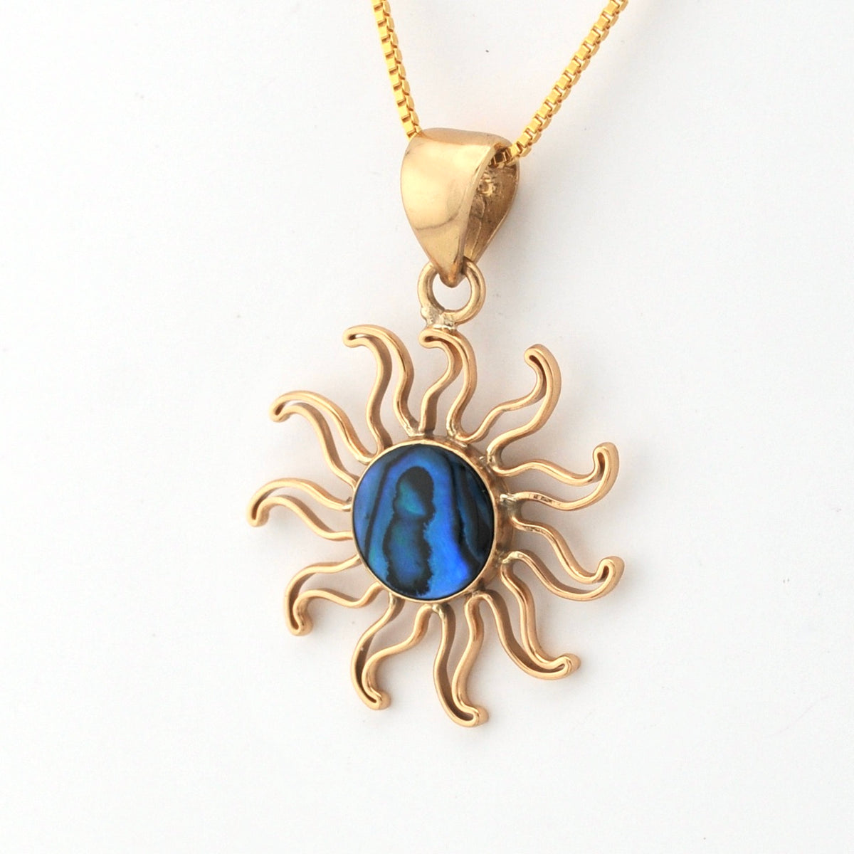 Gold sun-shaped pendant with a blue center on a white background