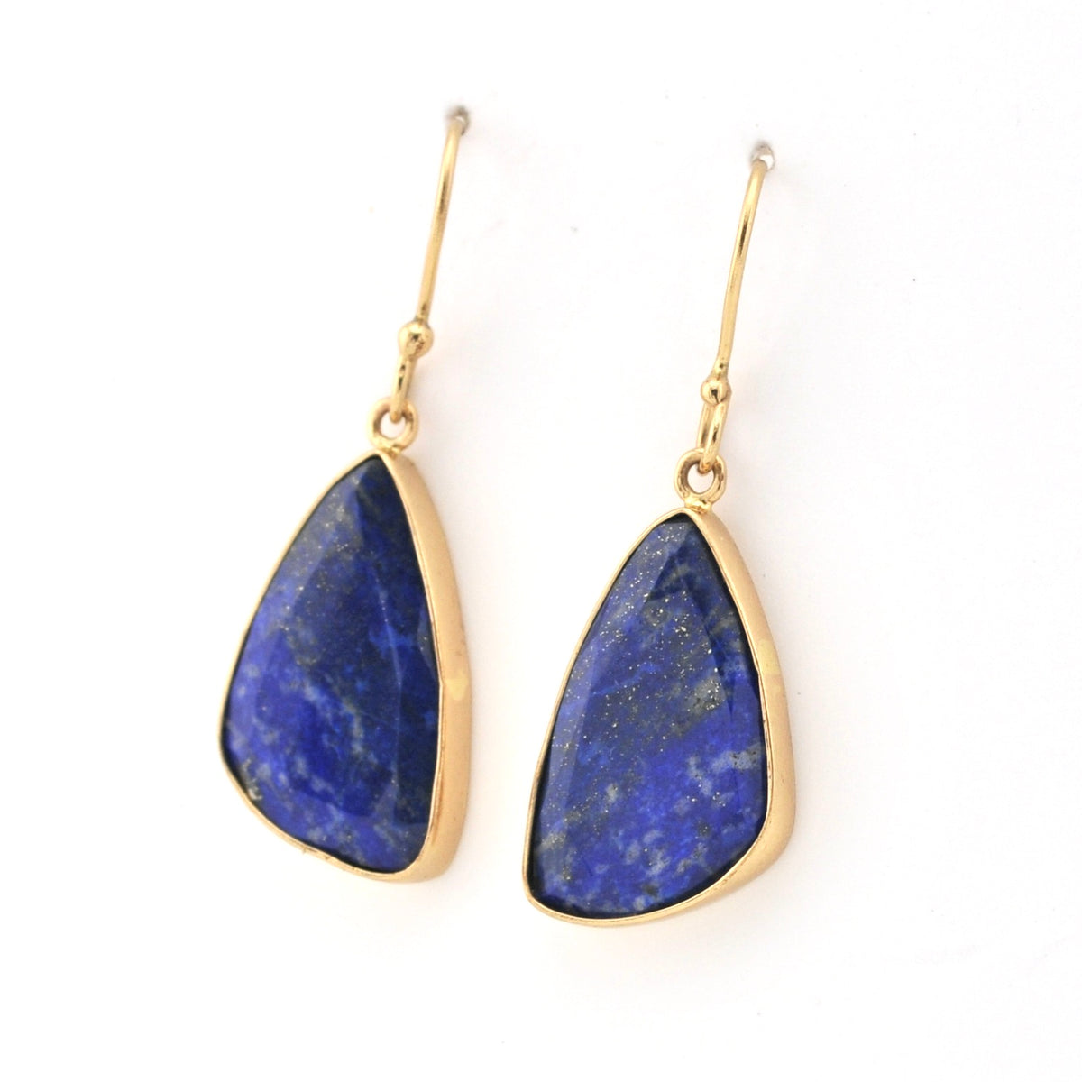 Pair of gold earrings with blue stone drops on a white background