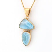 Gold necklace with a blue pendant on a white background