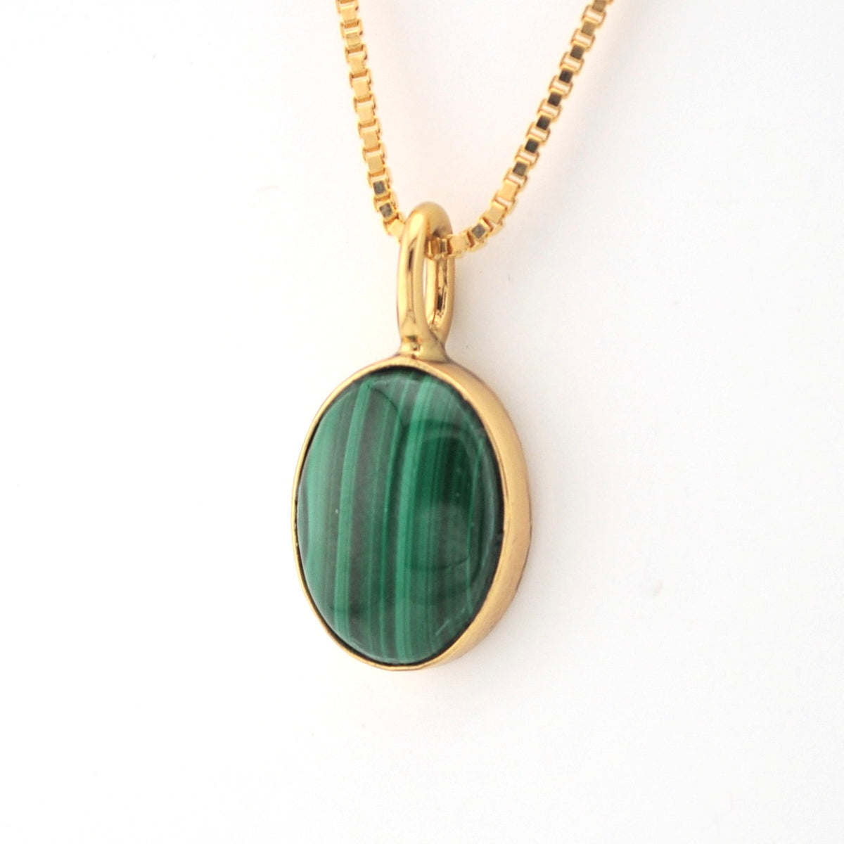 Gold necklace with a green stone pendant on a white background
