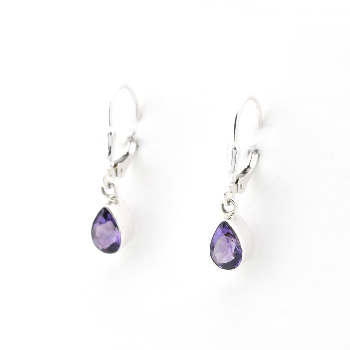 Pair of silver earrings with purple teardrop-shaped gemstones on a white background