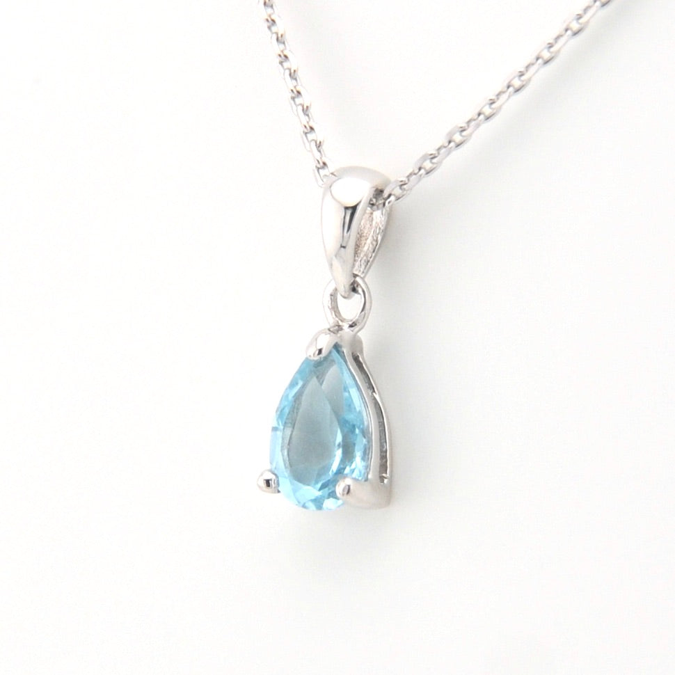 Teardrop-shaped blue gemstone pendant on a white background