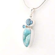 Jewelry with a large blue stone and smaller round gem on a white background