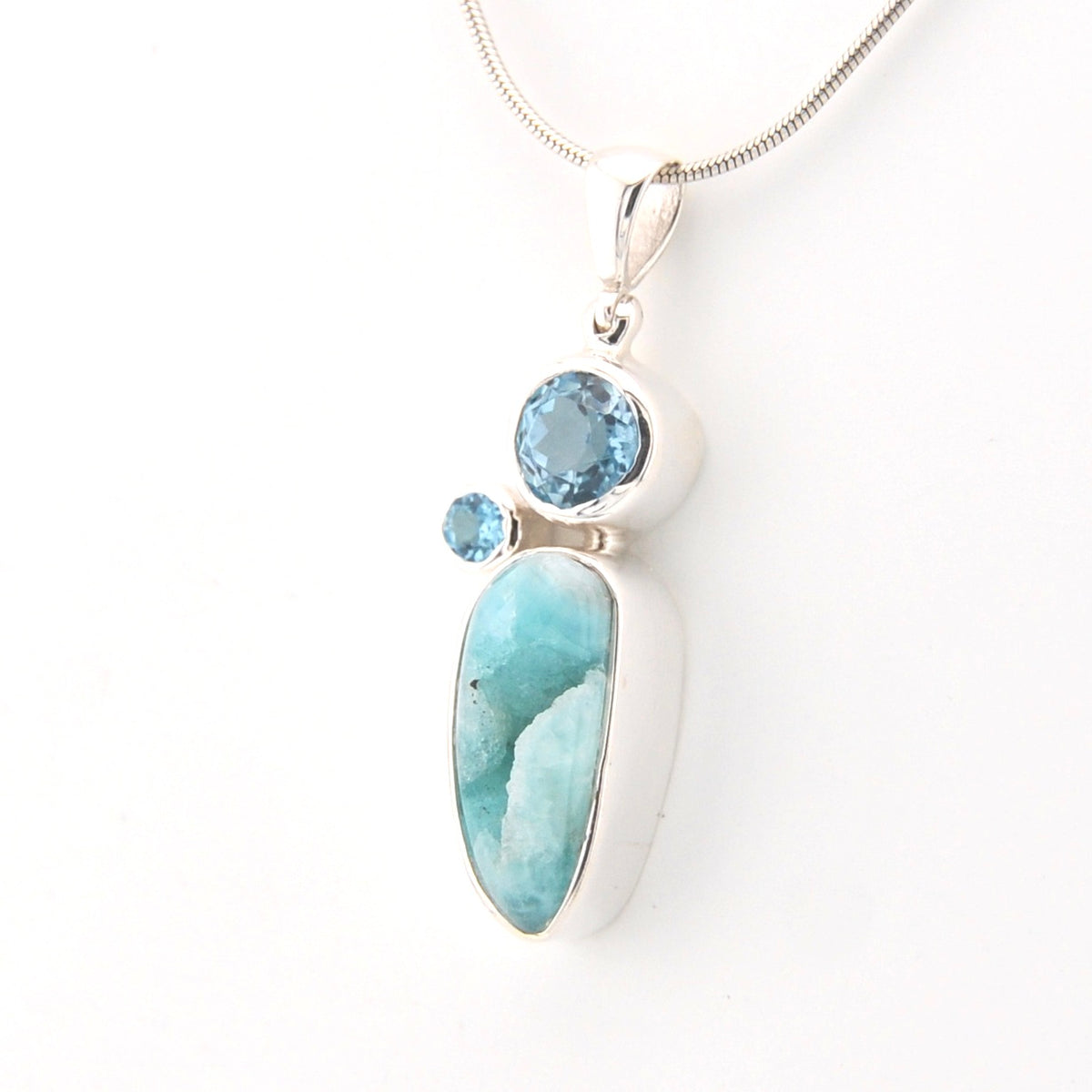 Jewelry with a large blue stone and smaller round gem on a white background