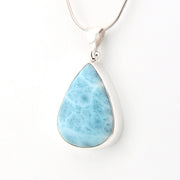 Teardrop-shaped larimar pendant on a silver chain against a white background