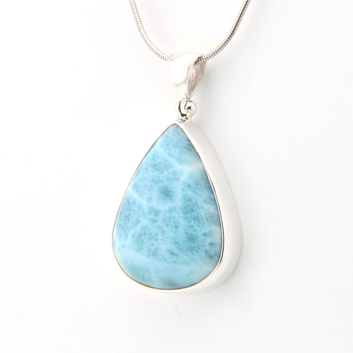 Teardrop-shaped larimar pendant on a silver chain against a white background