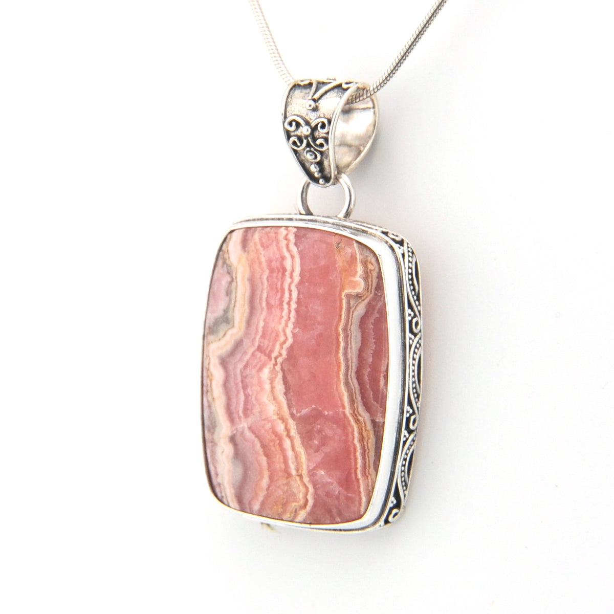 Pink stone pendant with silver setting on a white background