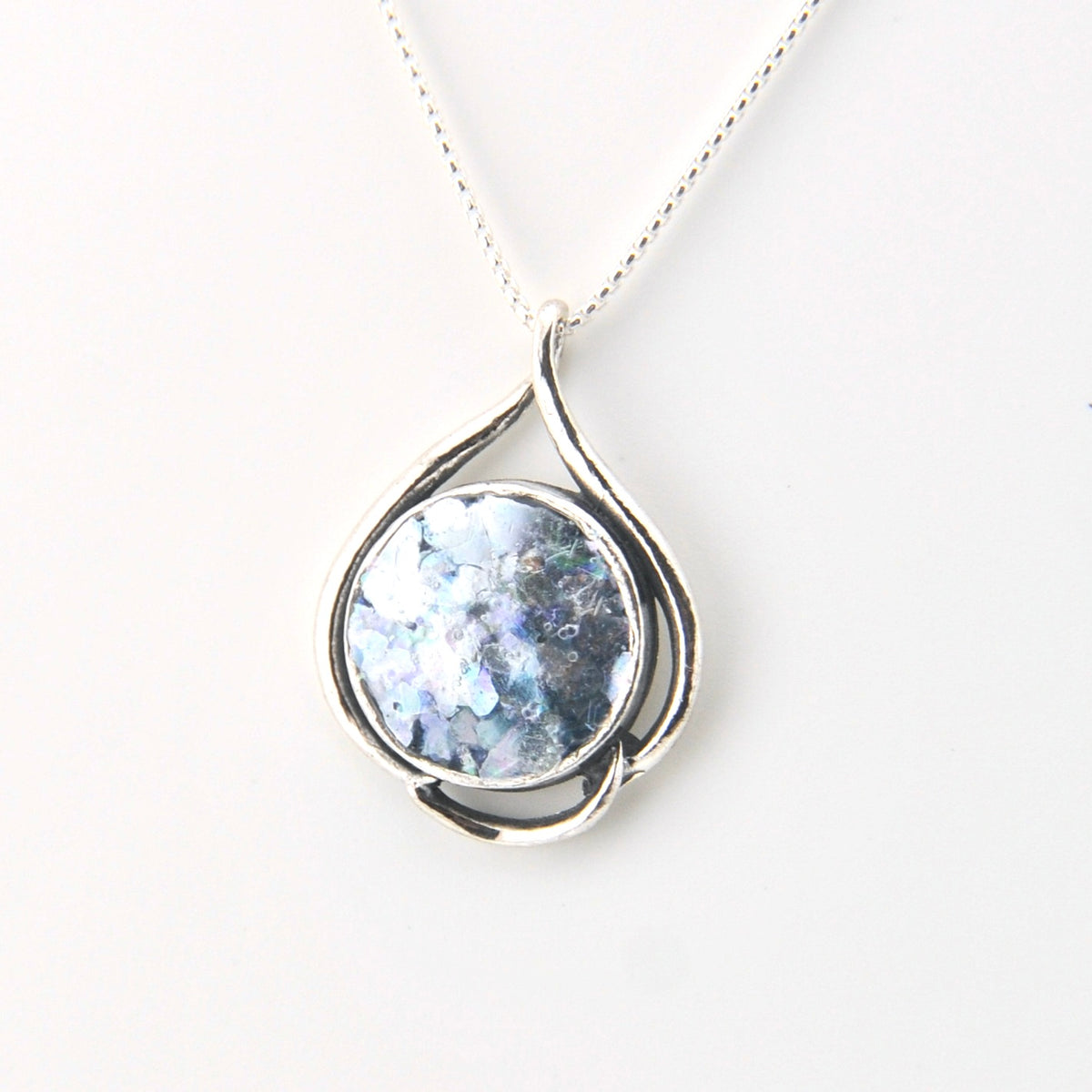 Silver pendant with a blue gemstone on a white background