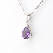 Purple teardrop pendant on a silver chain against a white background