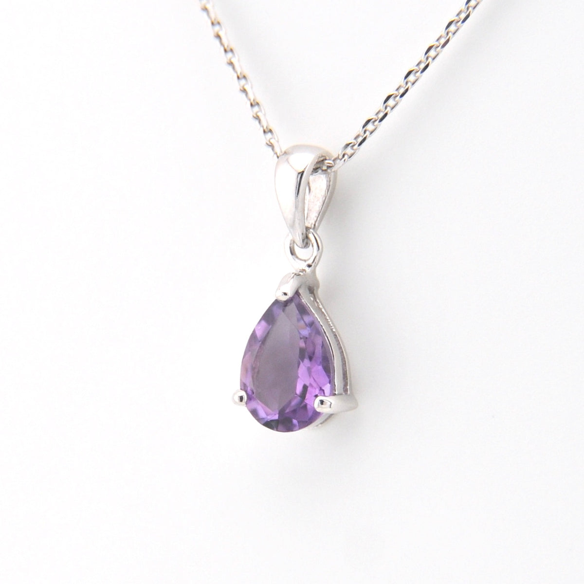 Purple teardrop pendant on a silver chain against a white background
