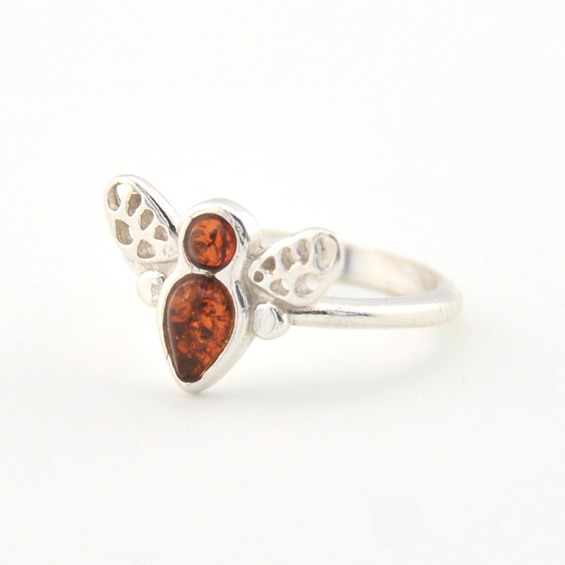 Silver ring with a heart-shaped amber stone on a white background