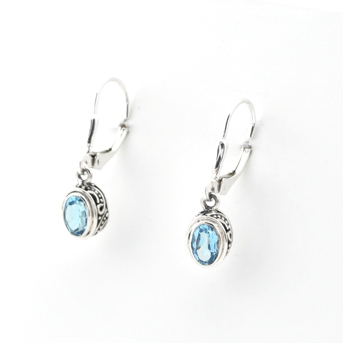 Silver earrings with blue gemstones on a white background