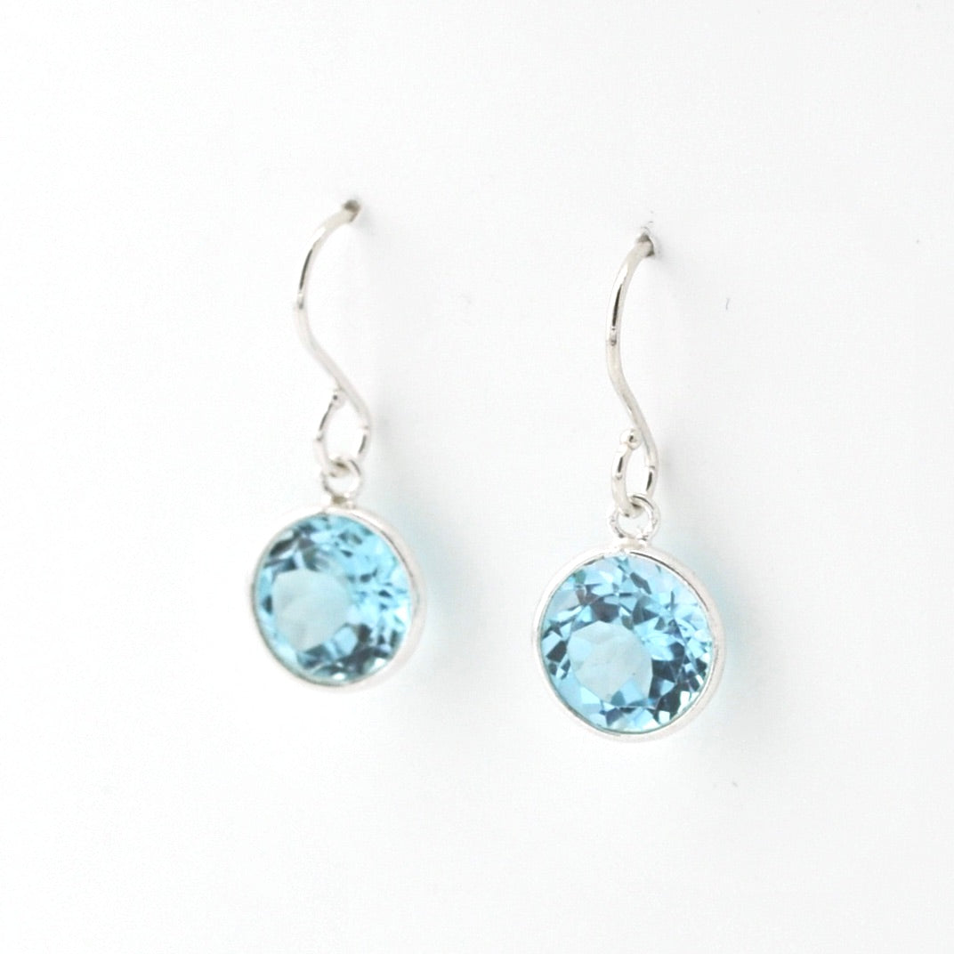 Pair of silver earrings with blue gemstones on a white background